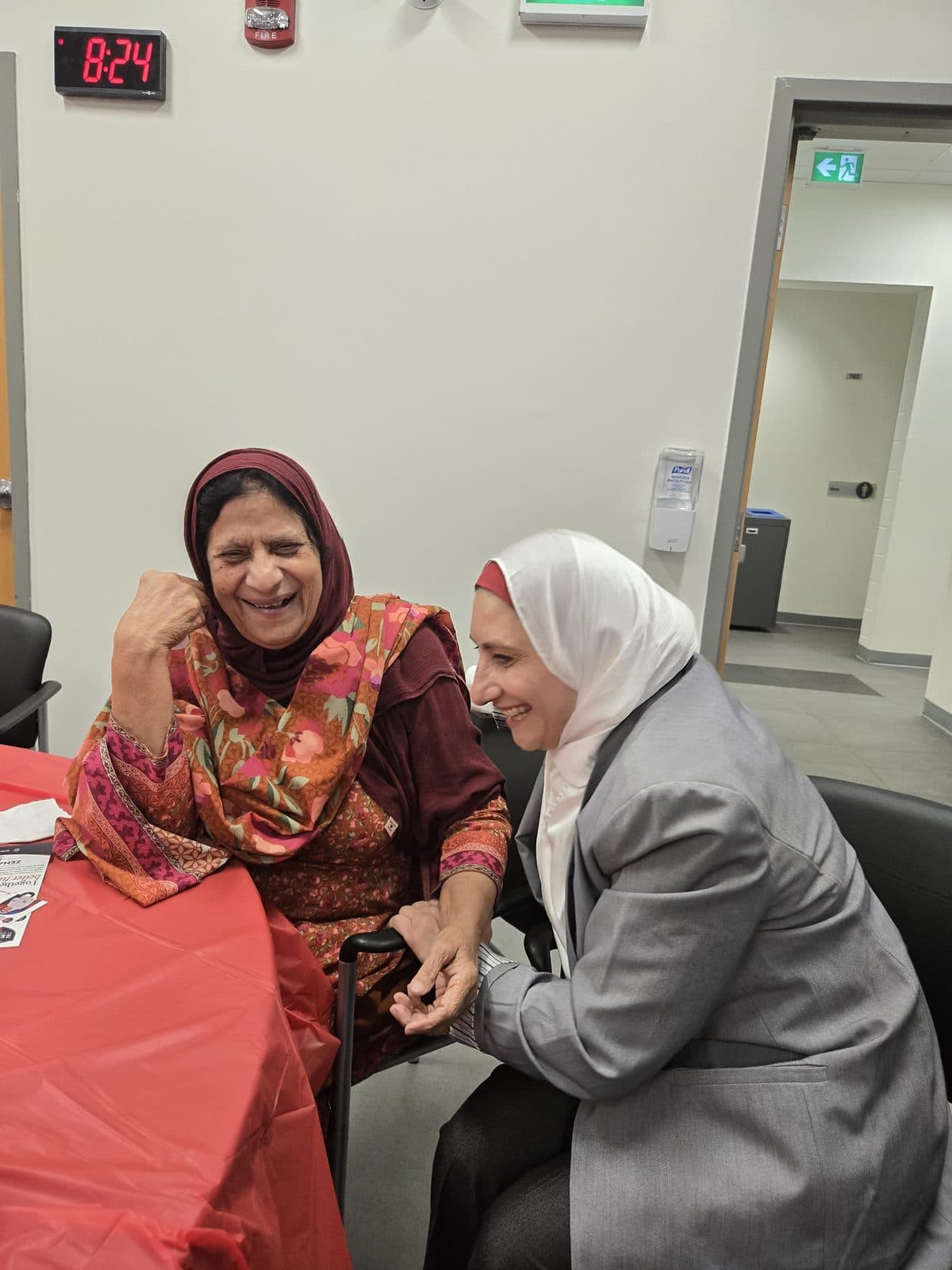 Zena shares a laugh with a seated guest
